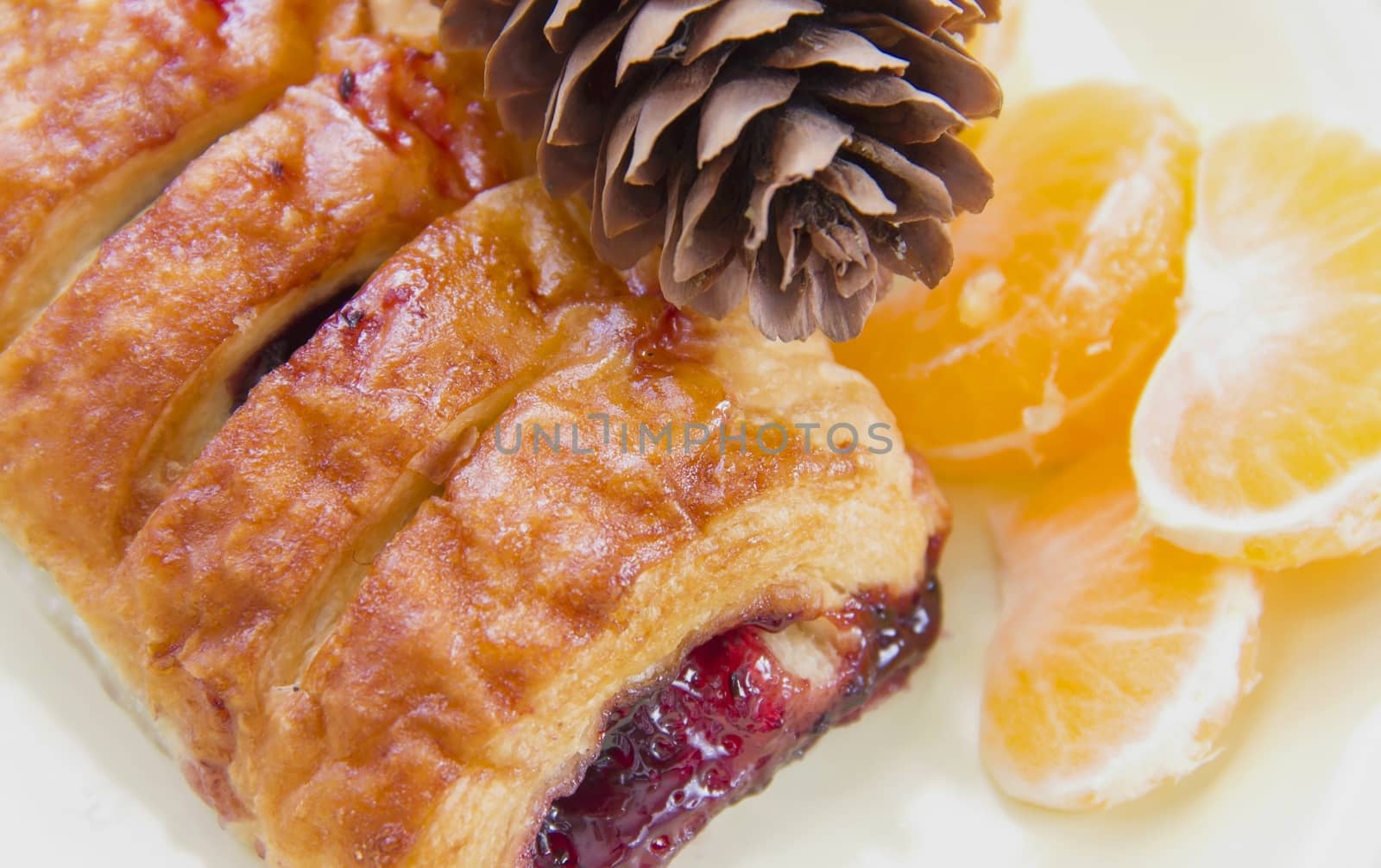 a croissant with jam, layered bun on a plate with mandarin oranges, tea and dessert winter festive dessert of fruit and soft focus