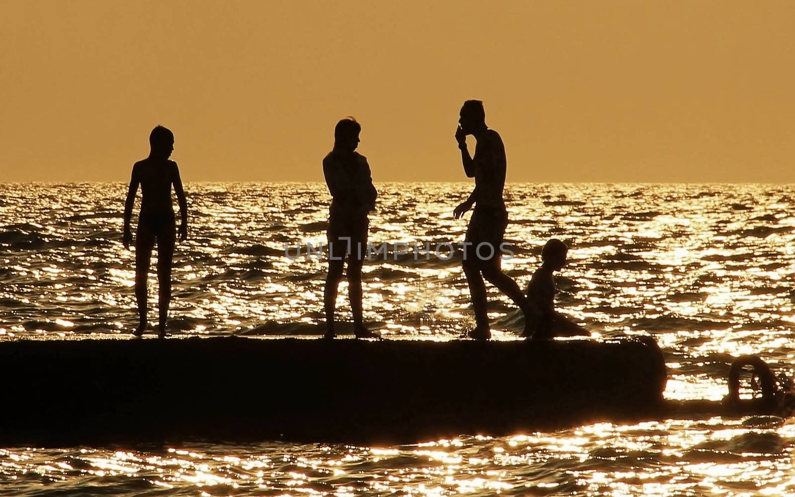 people silhouettes on the sea at sunset Family resting by KoliadzynskaIryna