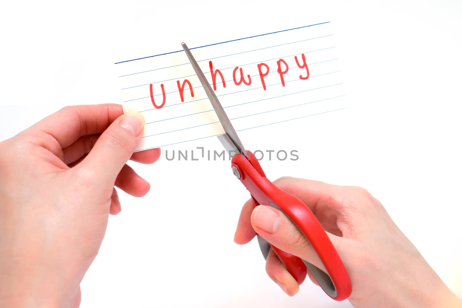 Female using scissors to remove the word unhappy to read happy concept for self belief, positive attitude and motivation