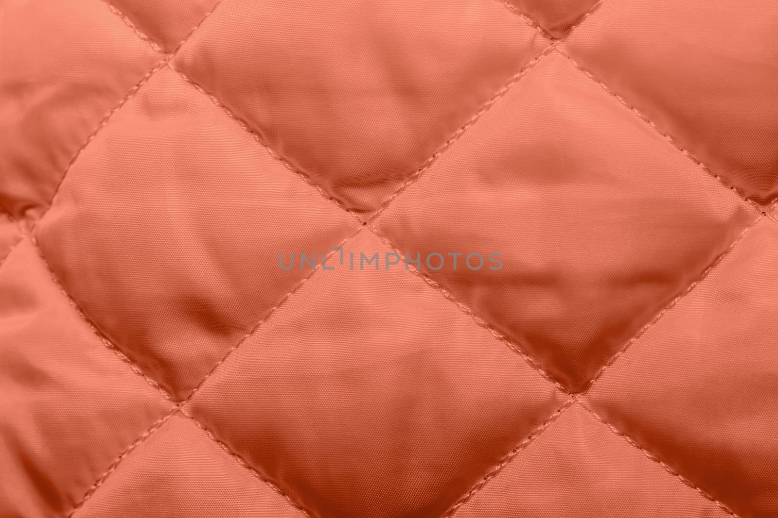 quilted fabric texture of coral color for hammering, backgrounds and textures