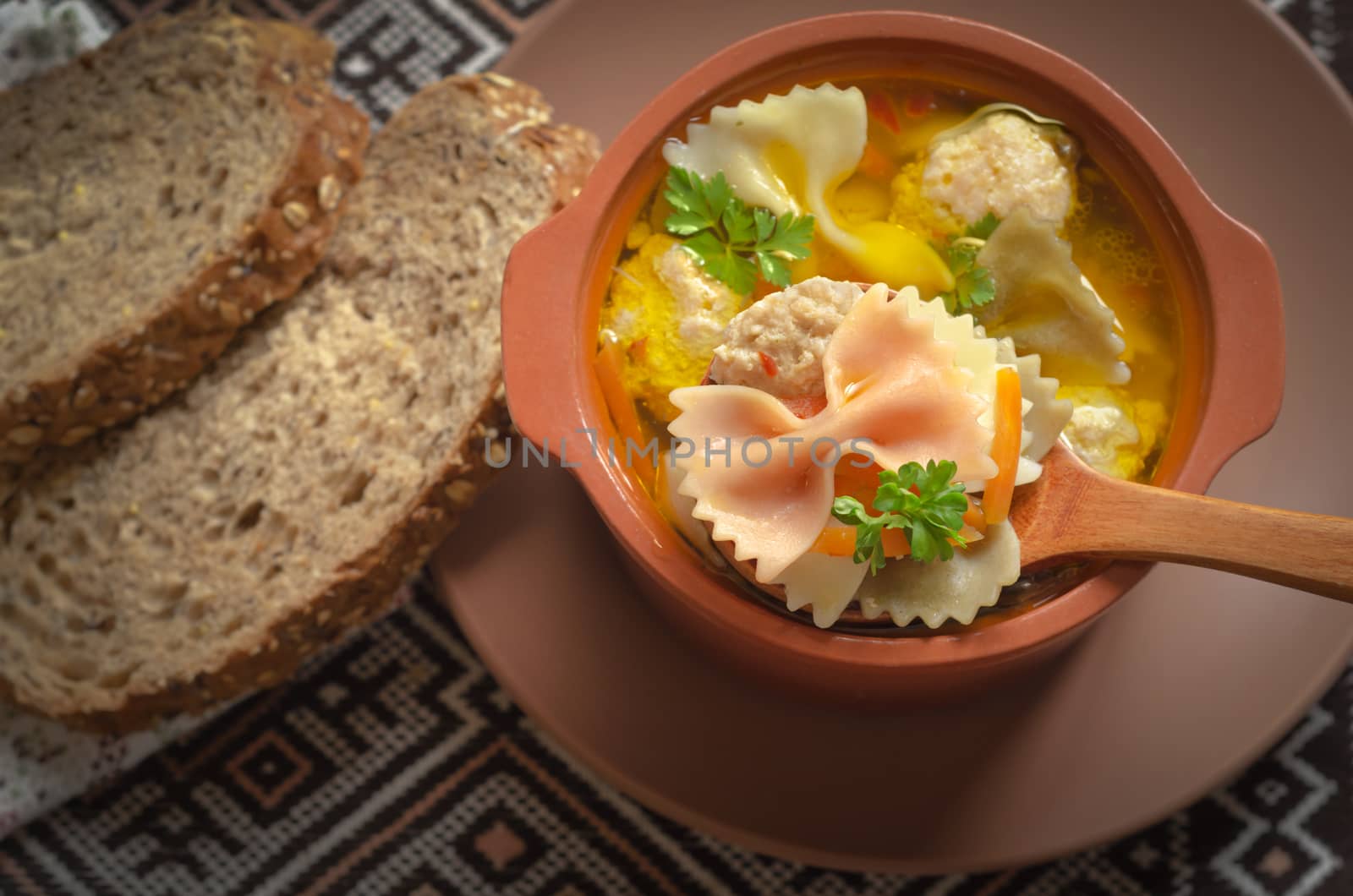 Italian soup and bread, on old embroidered towels, low key.