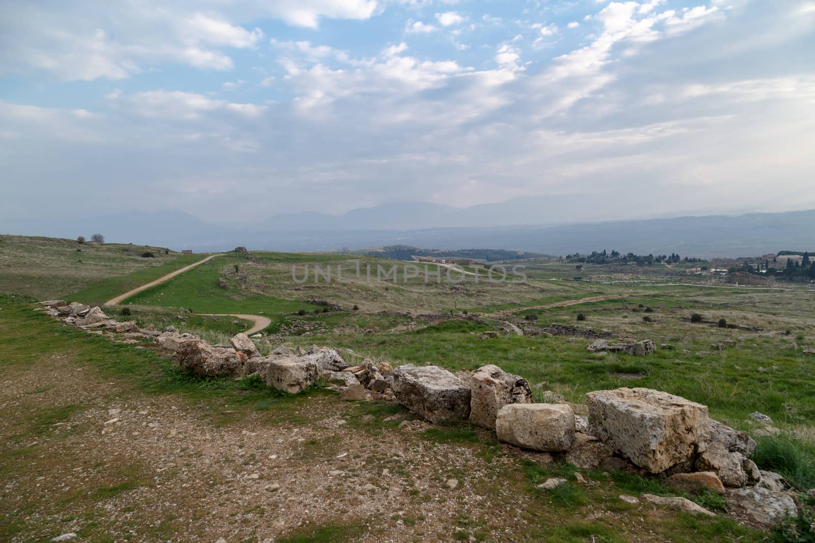 View of Hyerapolis Ancient City with stone ruins on cloudy sky background.