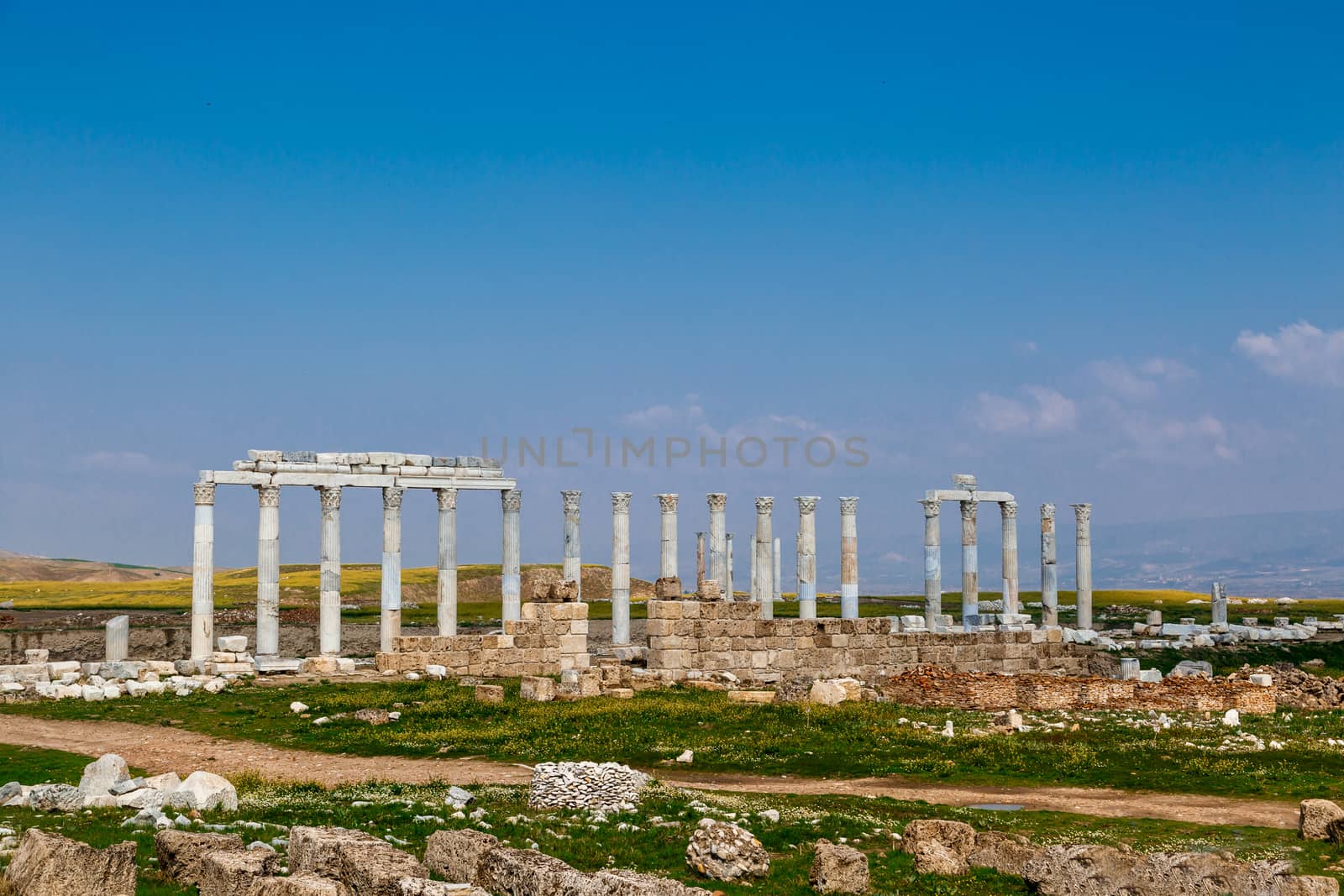 View of historical ancient city of Laodicea in Denizli with high columns on bright blue sky background.