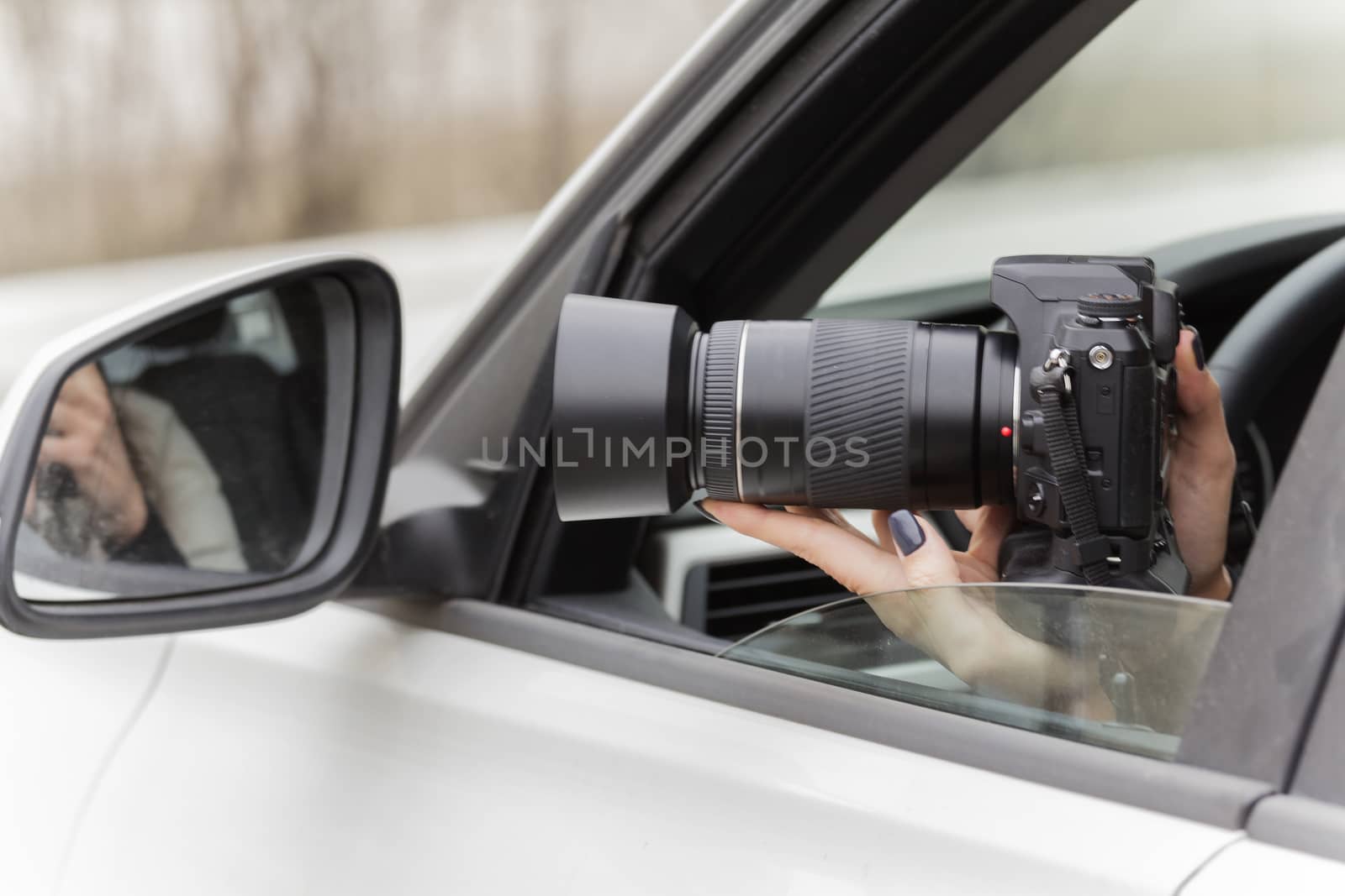 a girl takes pictures from a car window