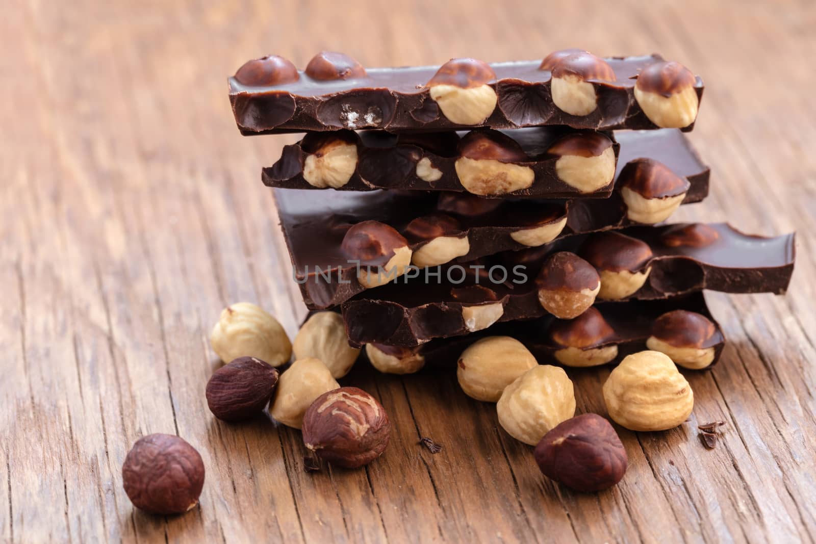 milk chocolate with hazelnuts on a wooden background