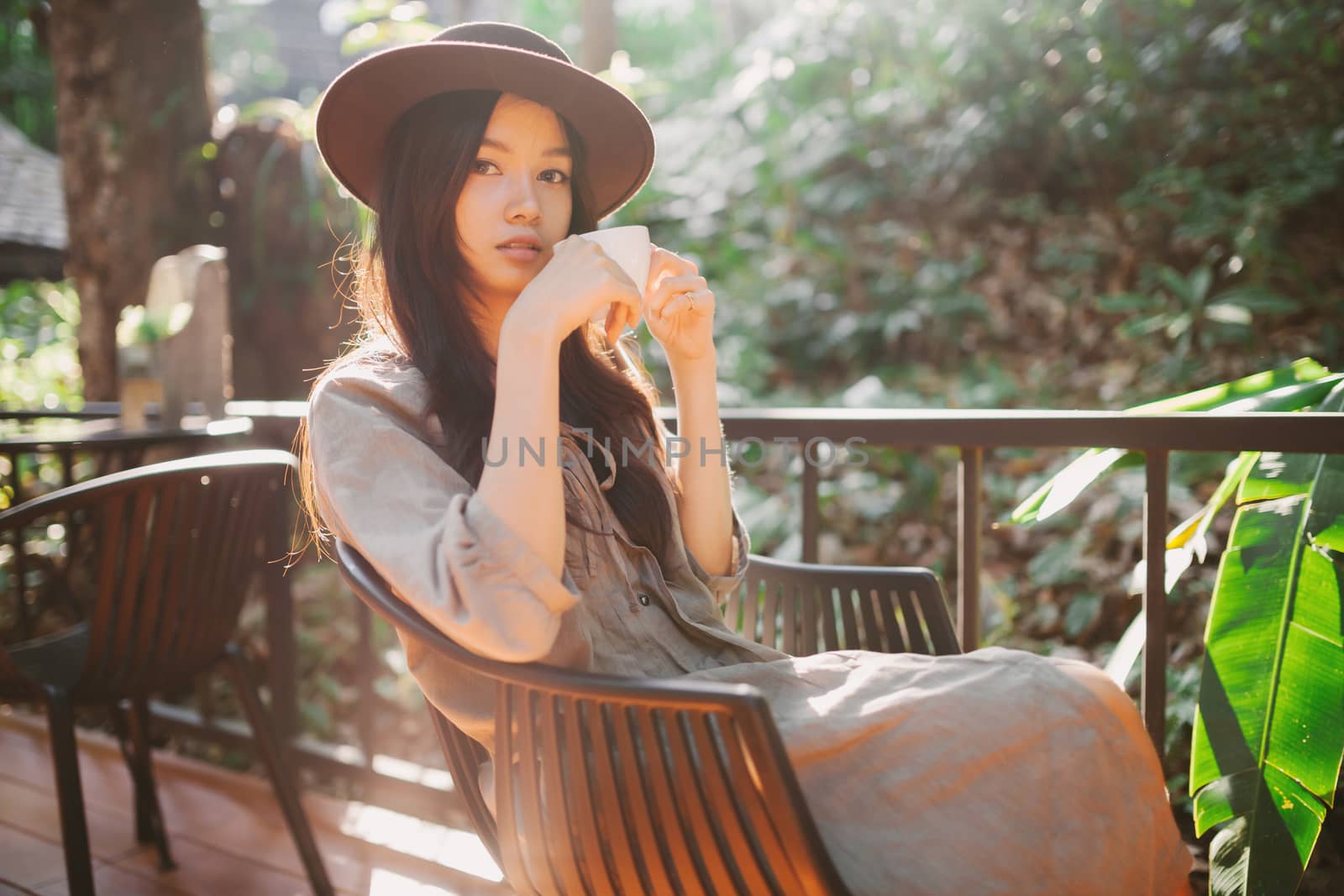Woman drinking coffee in the garden outdoor in sunlight light en by nopparats