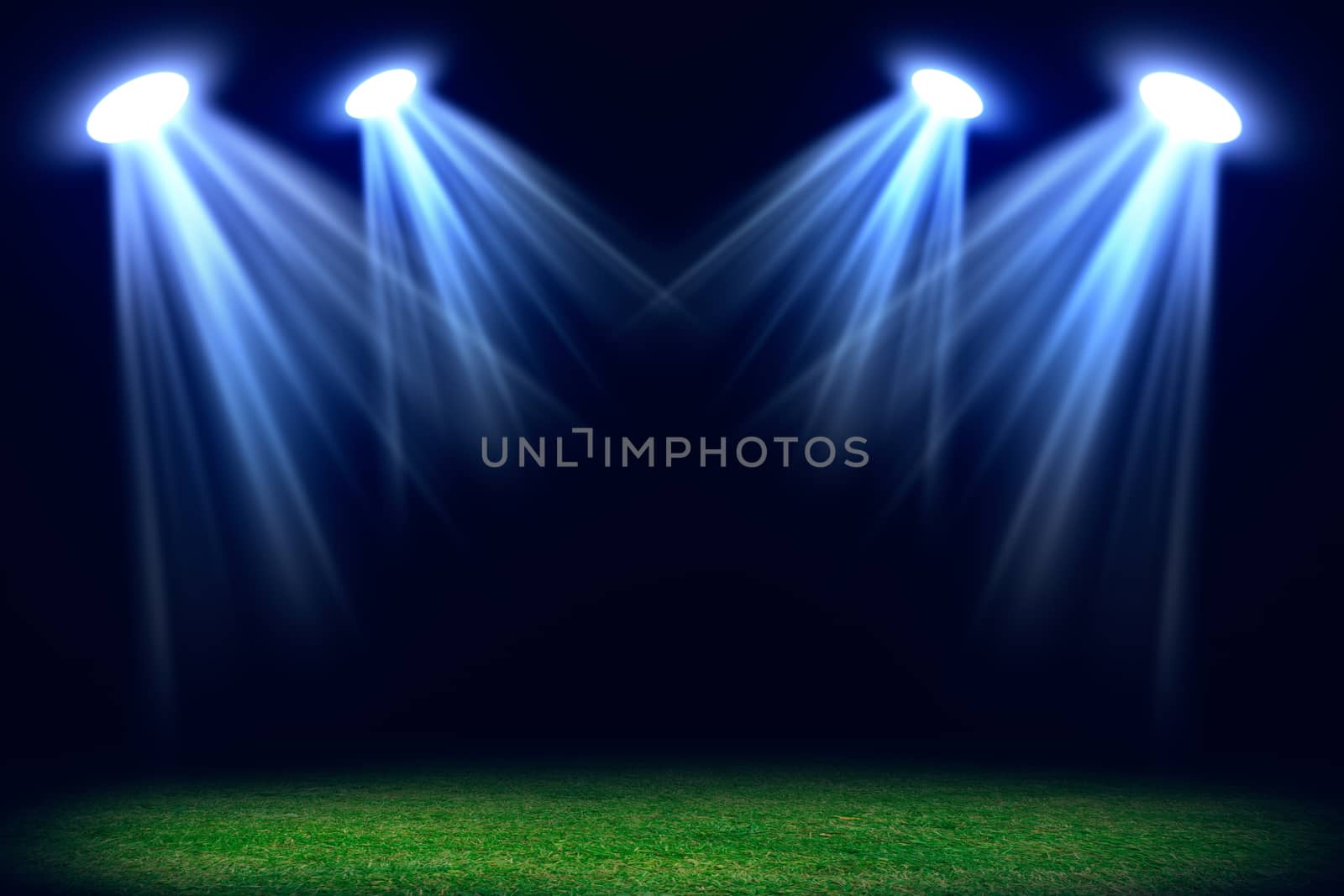 Grass field lit with bright spotlights by cherezoff