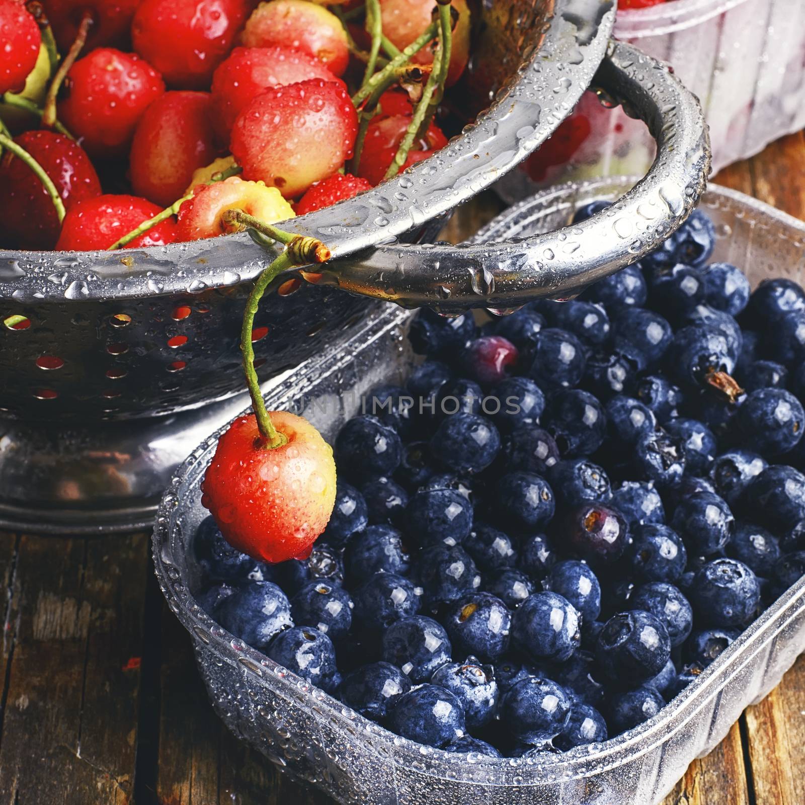 Harvest of ripe summer blueberries and cherries