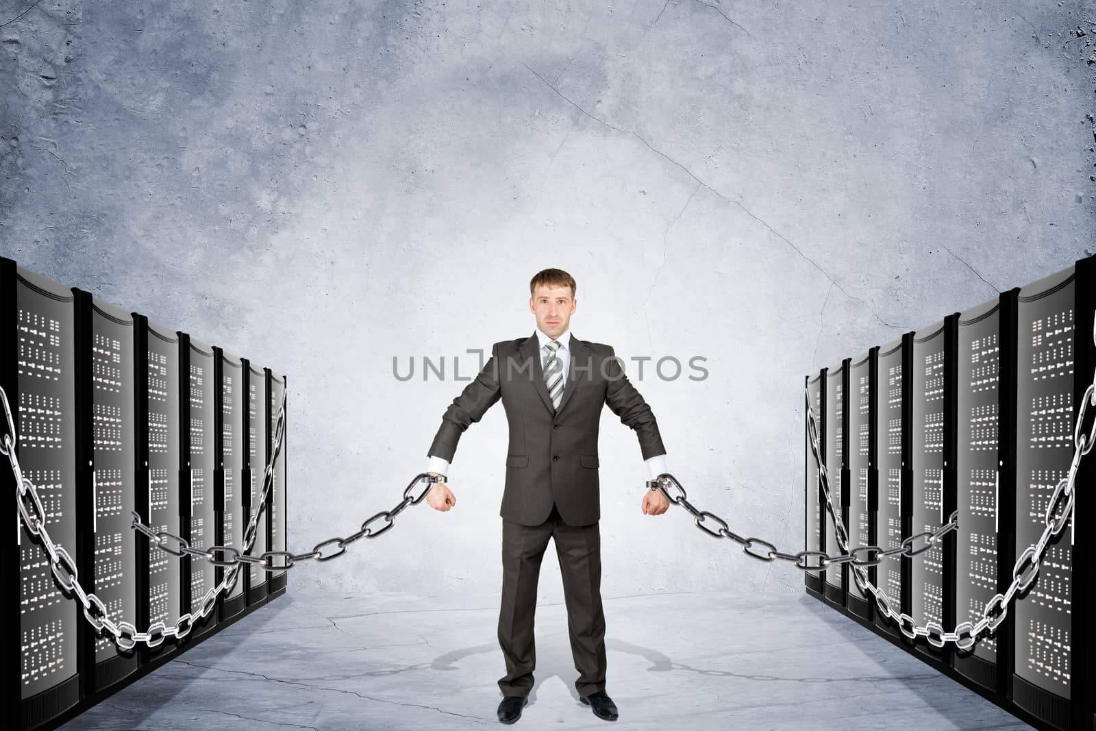 Businessman chained to iron boxes on grey background