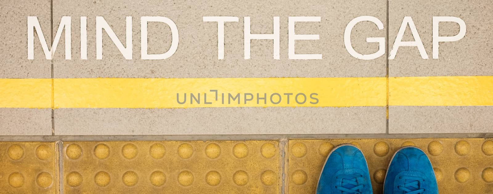 The sign " Mind the gap " painted on train station's platform edge by beer5020