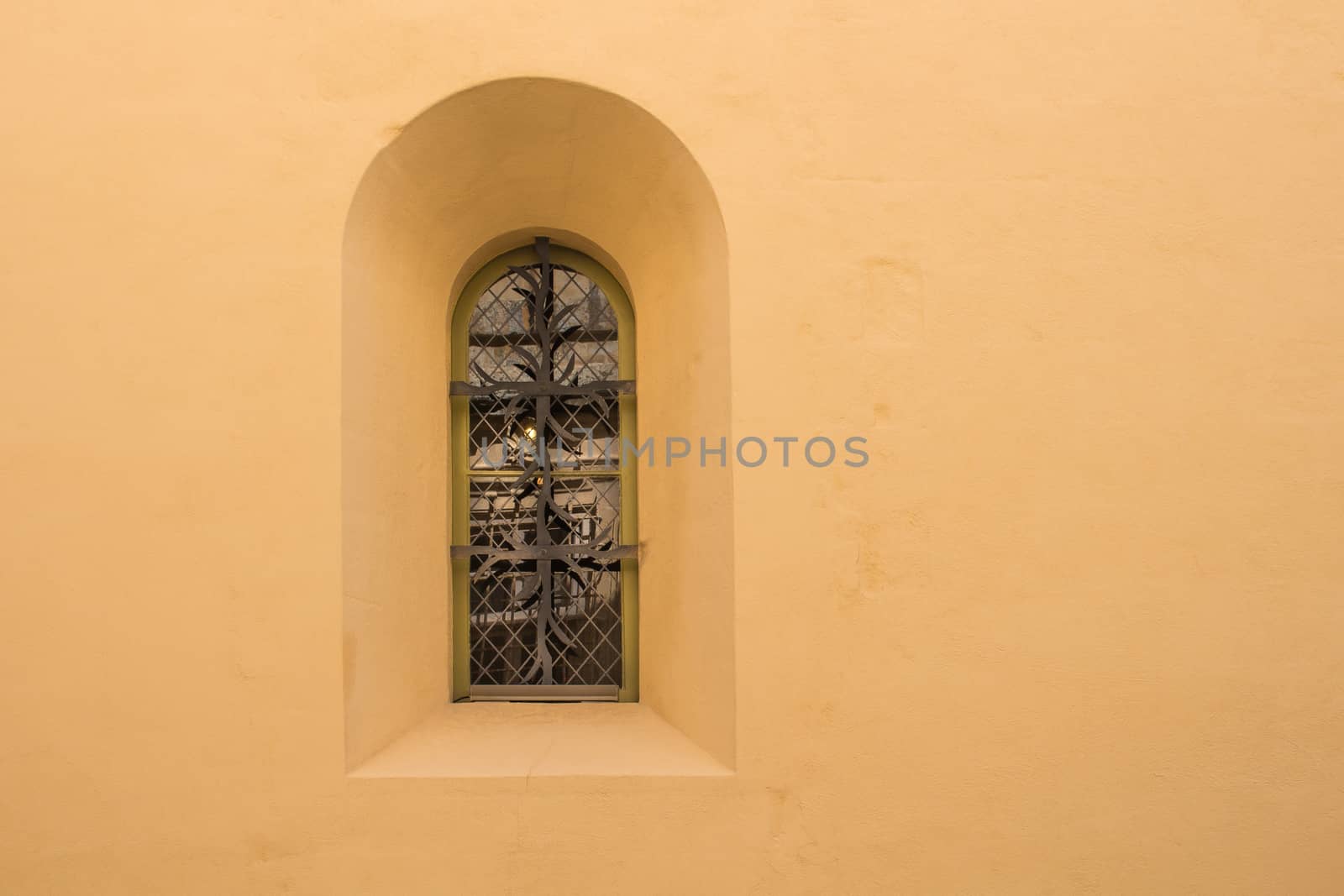 Yellow well preserved wall with a window with an arch. Former capital of Malta - Mdina. Fusion of arabian architecture and baroque.