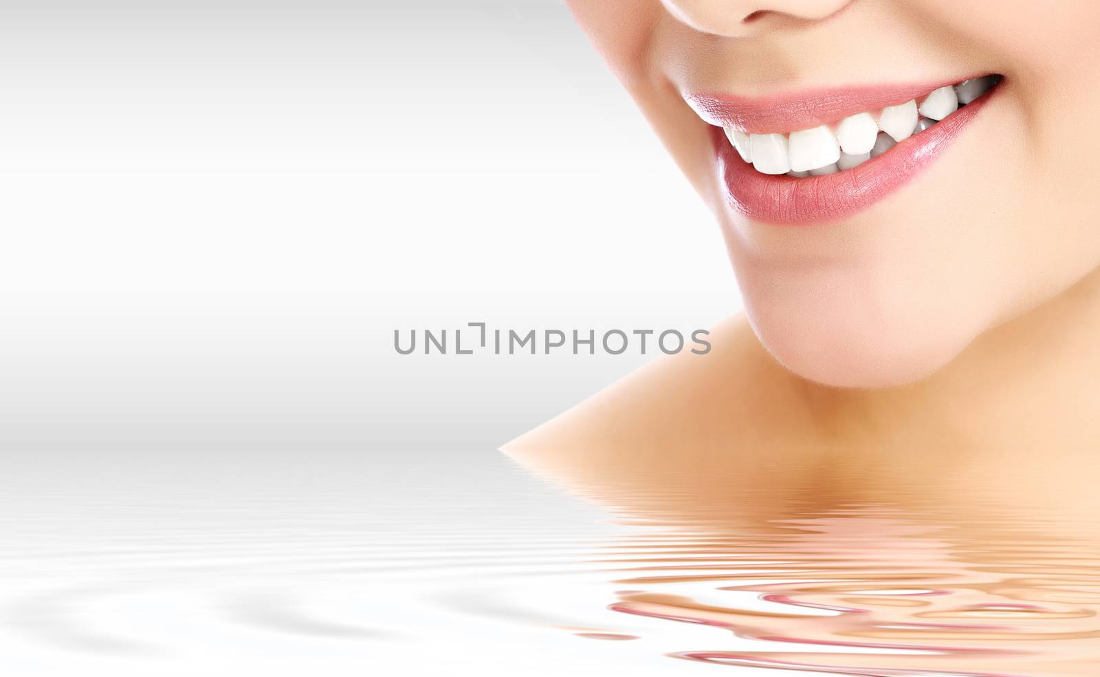 Pretty woman smiling against a grey background with copyspace