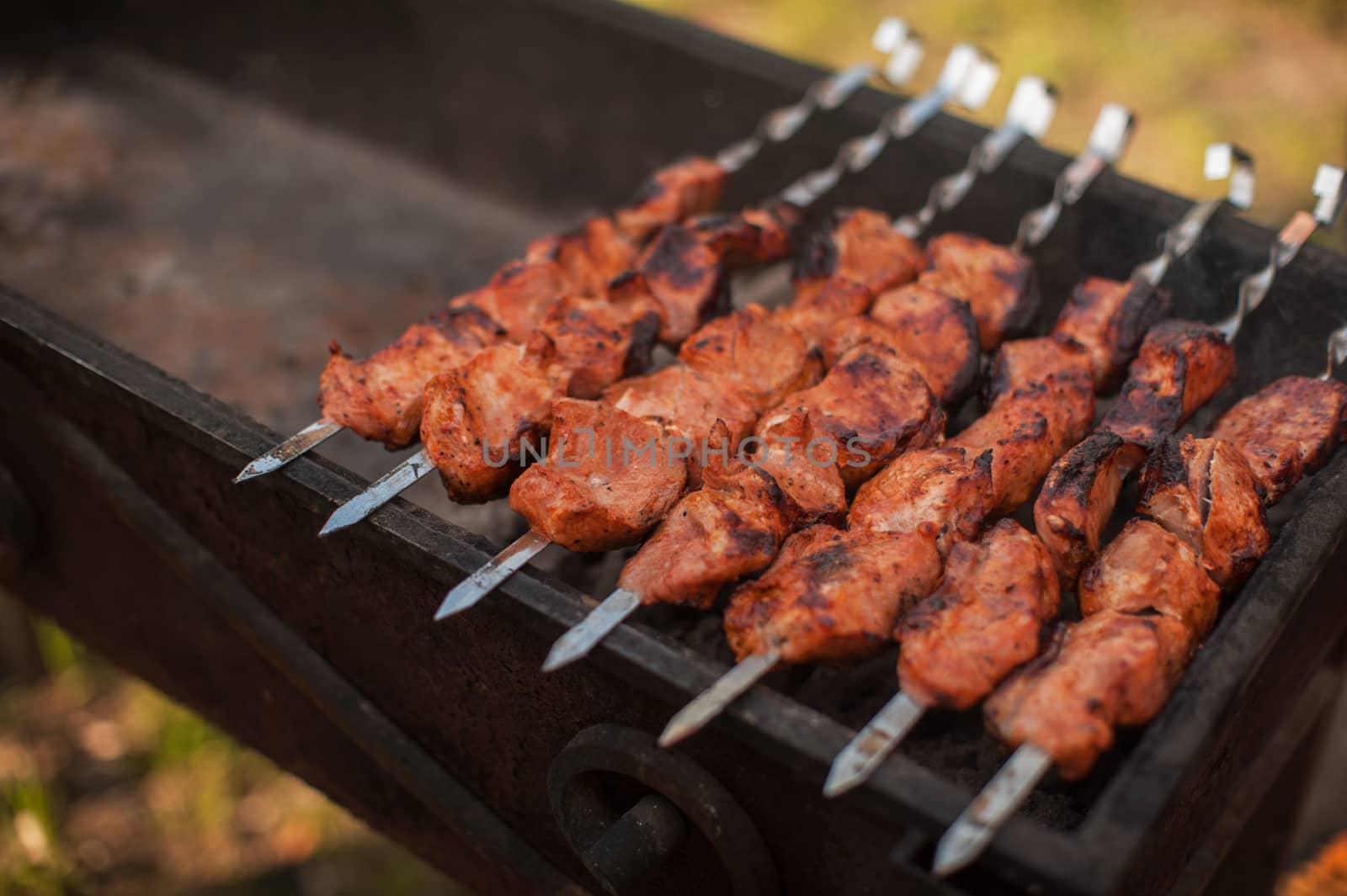 Grilling marinated pork meat on a grill