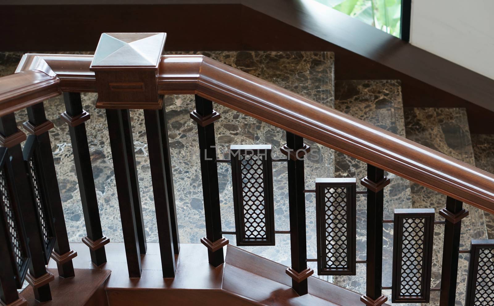 Elegant stairs with handrail decorated by stone and wood in the house.