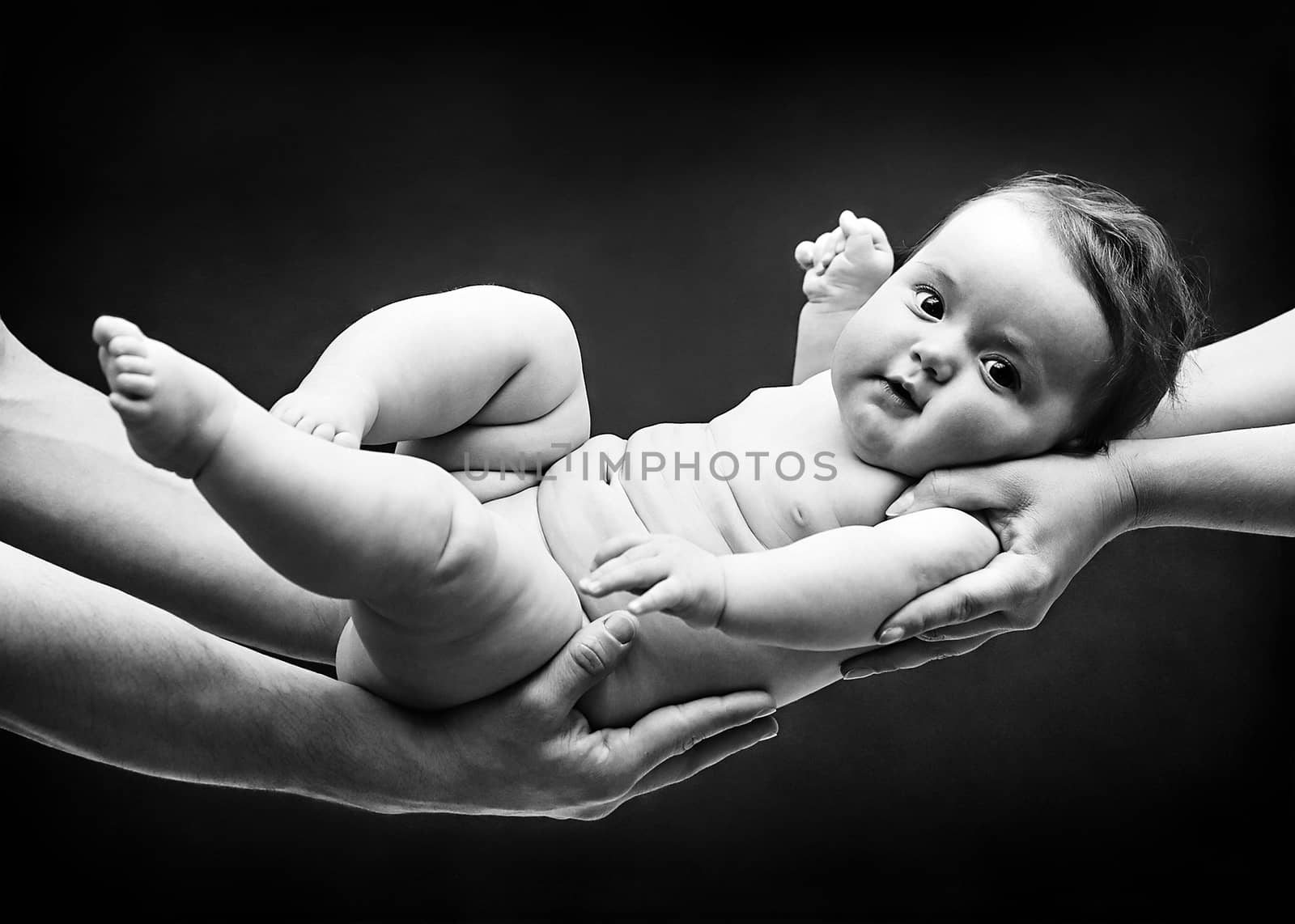 Parents Holding Baby Girl on their Arms by Multipedia