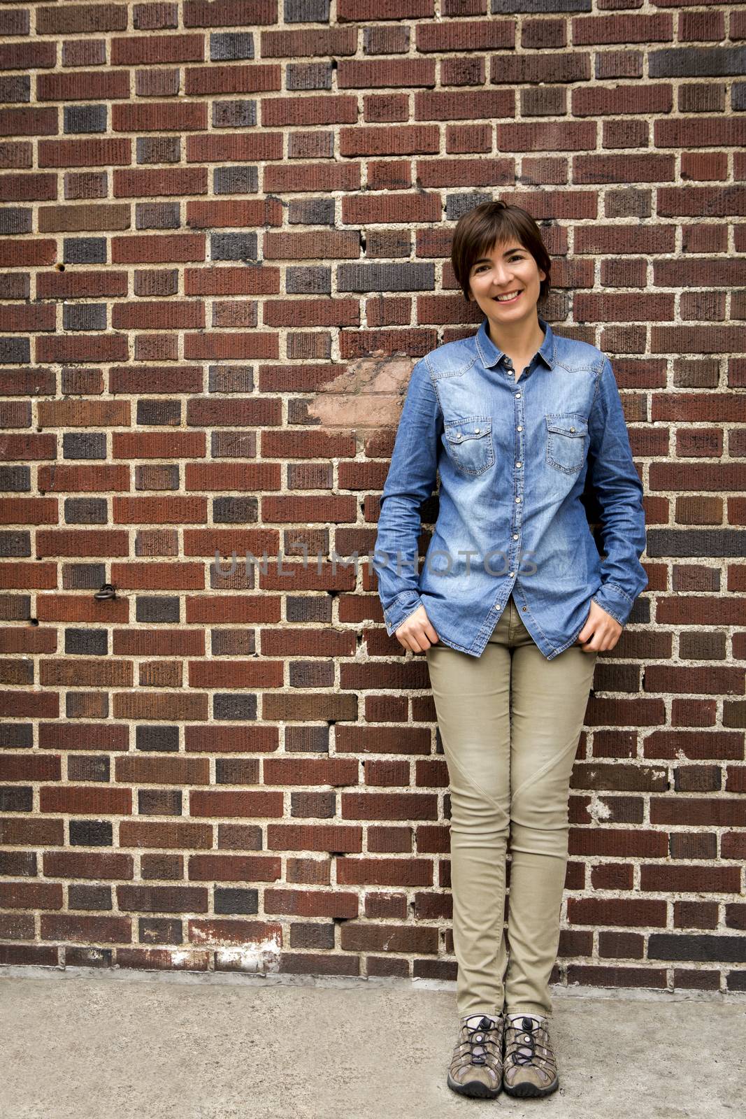 Outdoor portrait of a woman in front of a brick wall