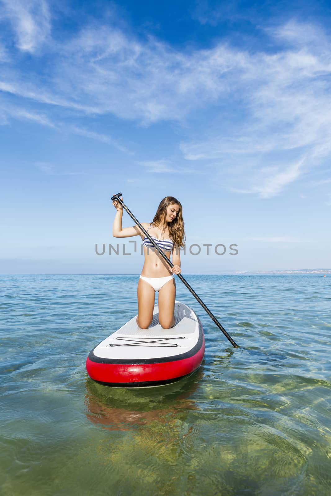 A beautiful woman practicing paddle on a beautiful sunny day