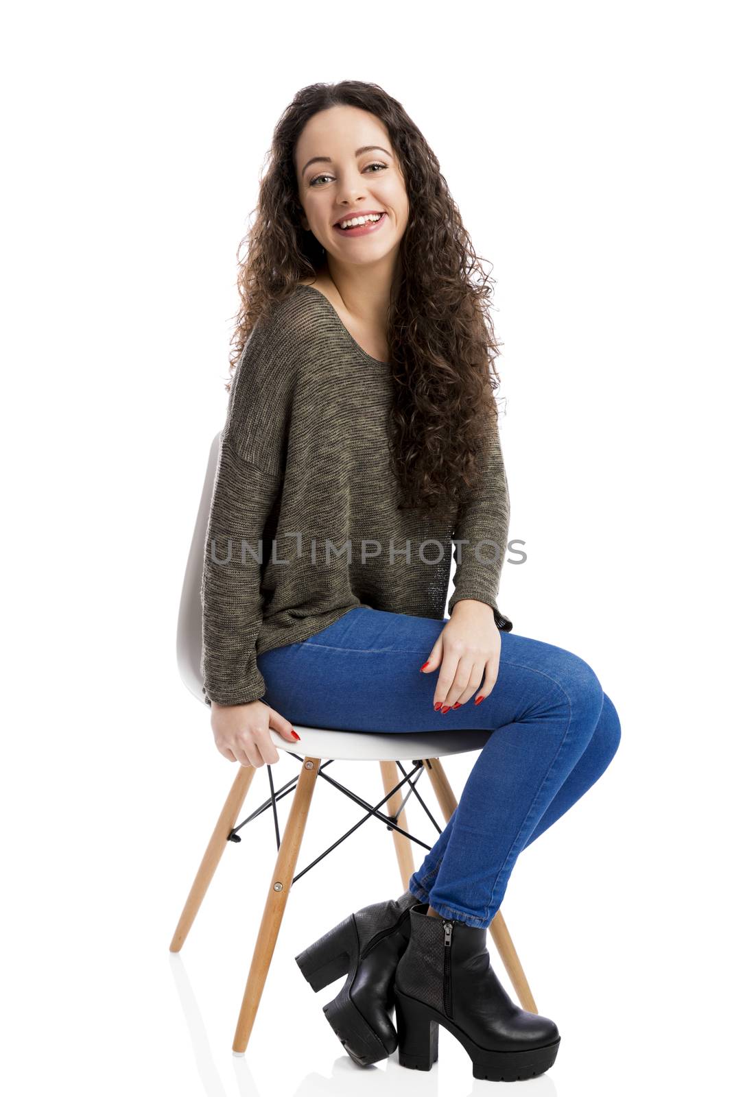 Beautiful woman sitting on a chair and smiling, isolated over white background 