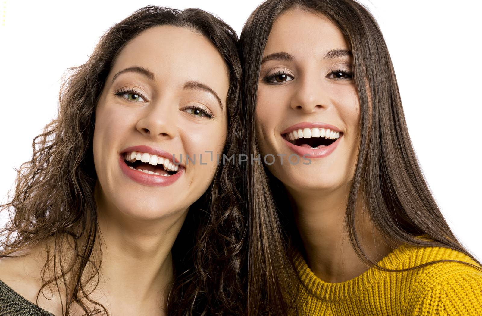 Studio portrait of two beautiful girls smiling