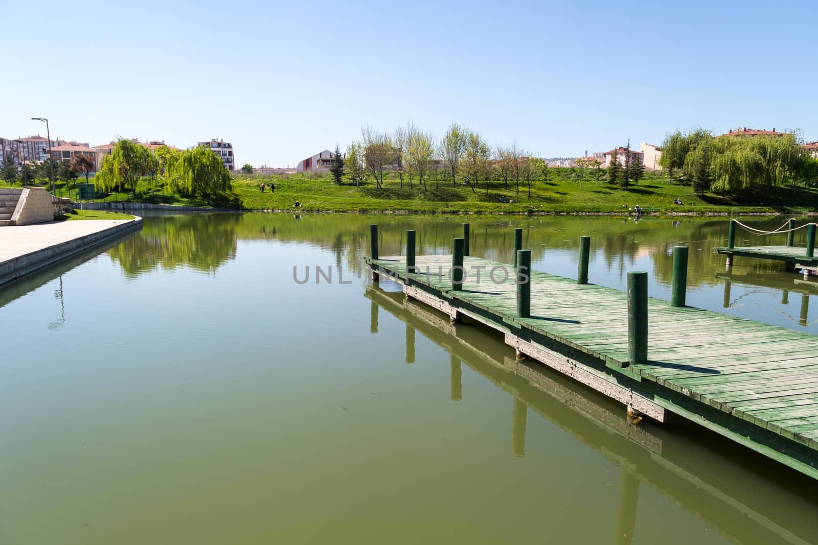 Landscape view of Porsuk River along Eskisehir with meadow area around, on bright blue sky background.