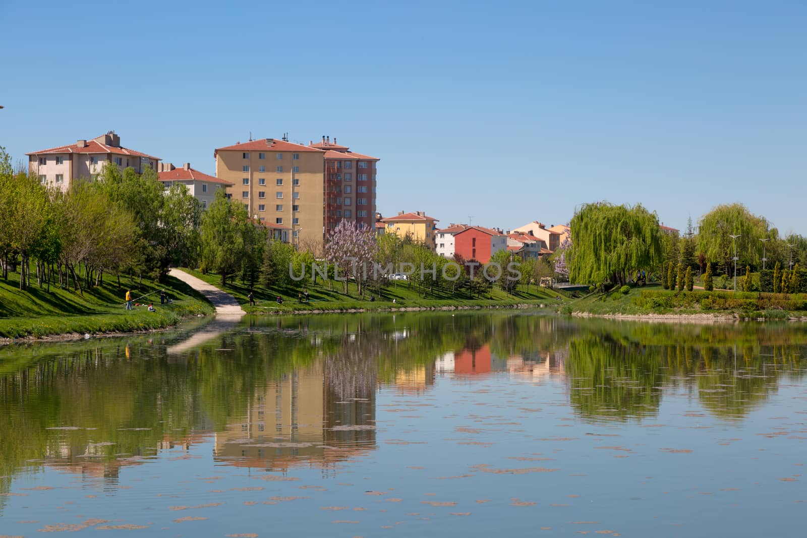 Landscape view of Porsuk River along Eskisehir with meadow area around, on bright blue sky background.