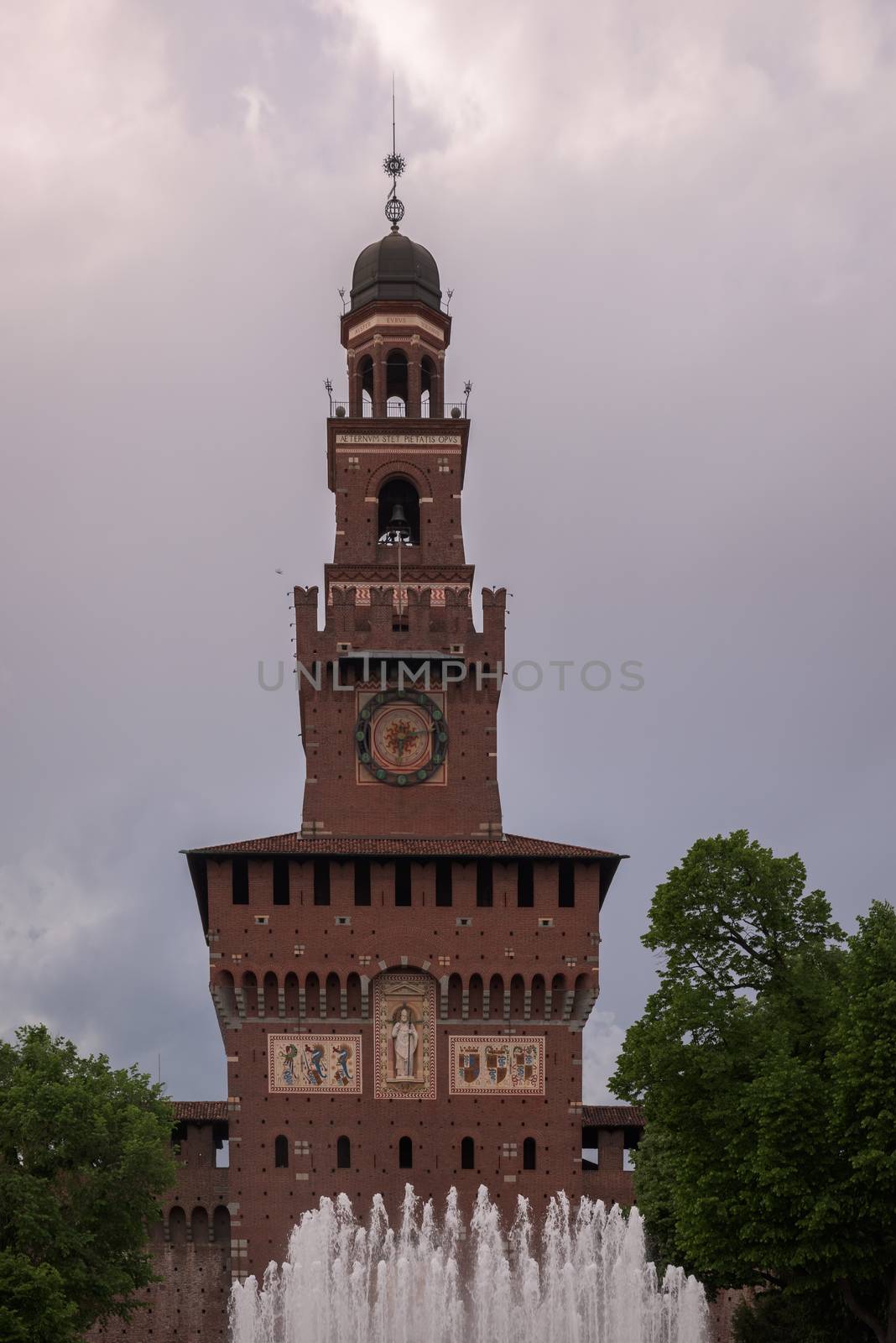 In the picture a view of famous fountain and the Sforza Castle tower in Milan, Italy.