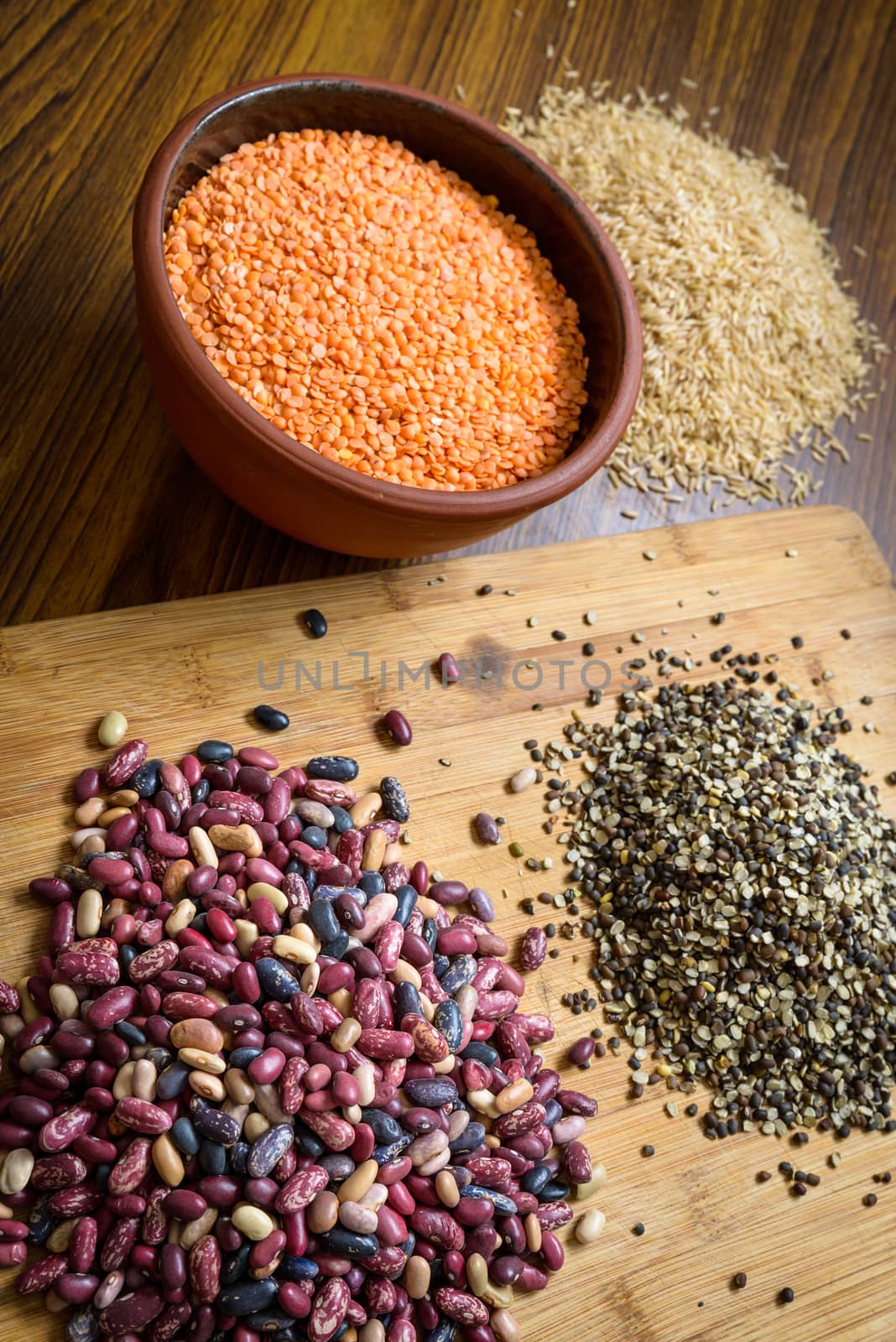 Lentils, red beans and brown rice on a wooden table and board