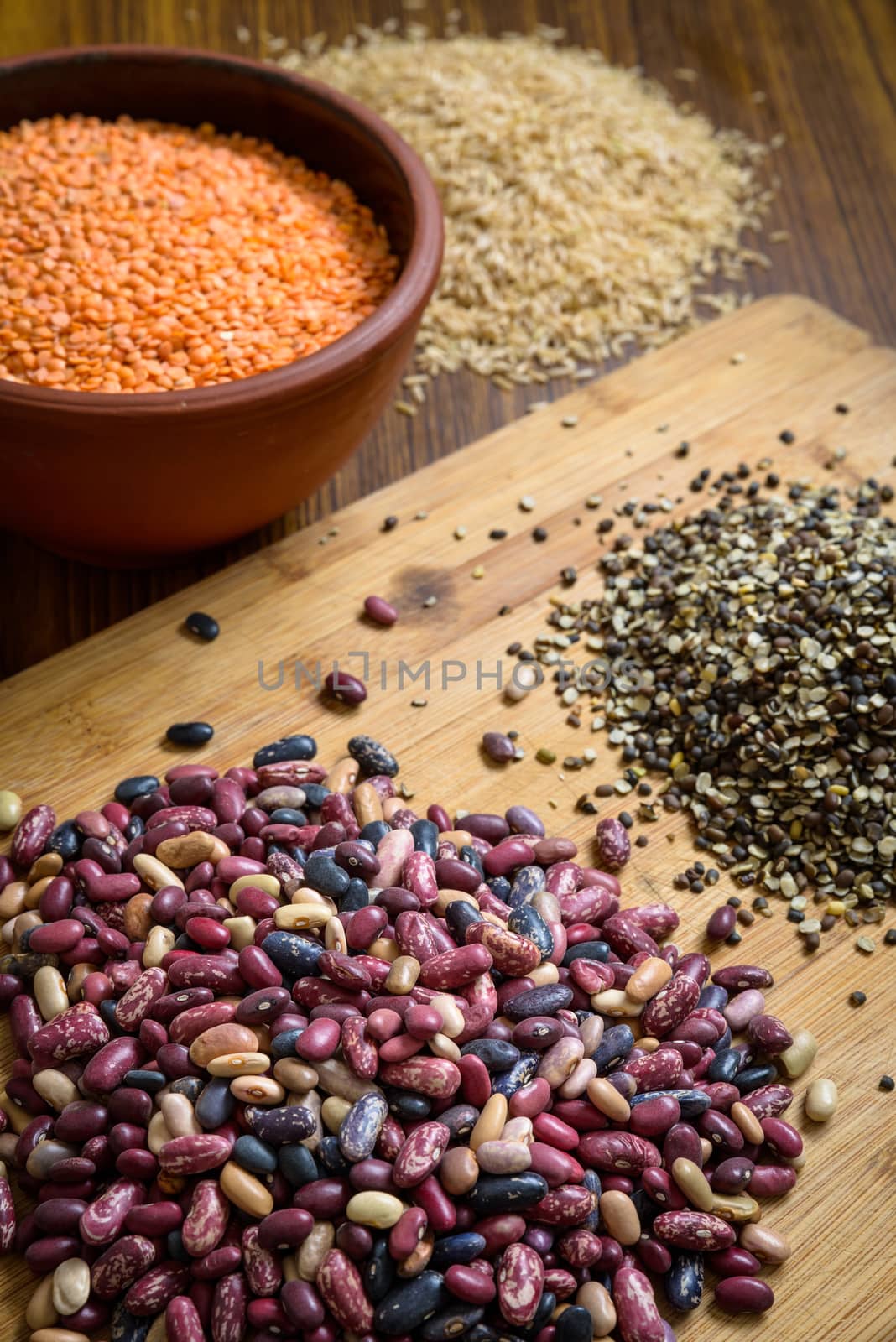 Lentils, red beans and brown rice on a wooden table and board