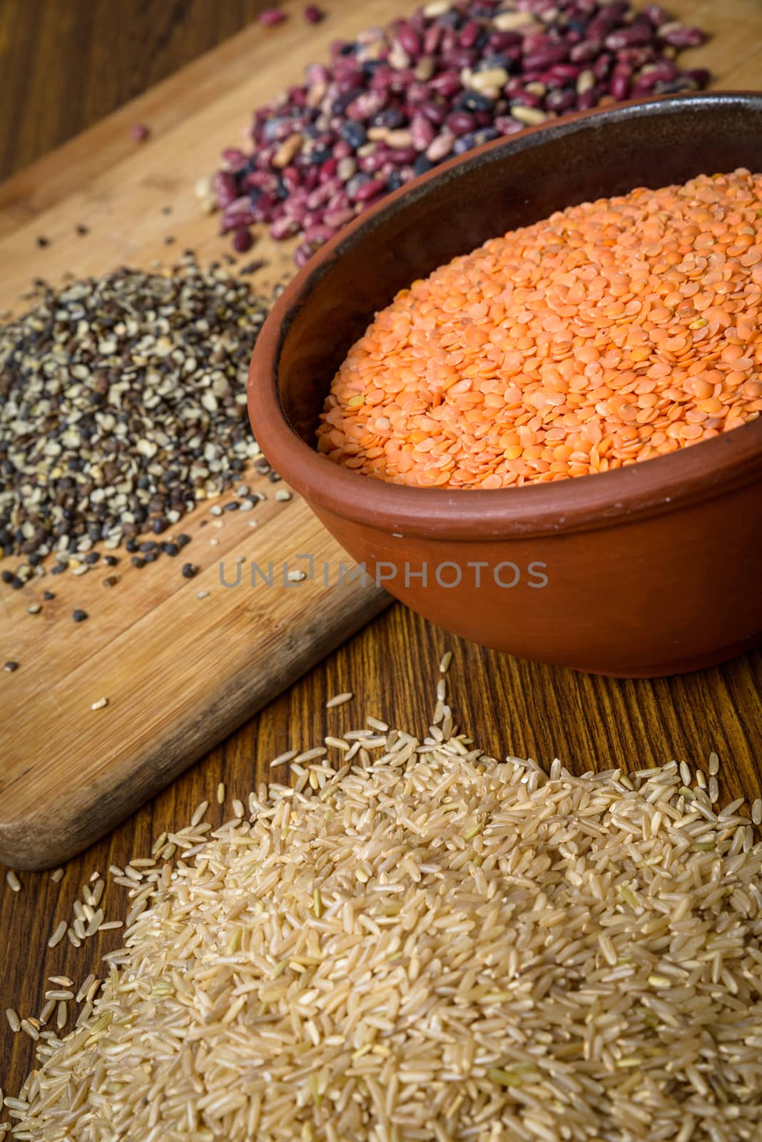 Lentils, red beans and brown rice on a wooden table and board