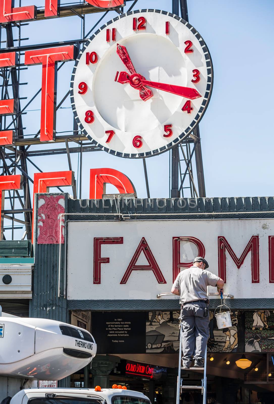 SEATTLE, WA - MAY 12: Unidentified male worker paints famous sign at Pike Place Market. May 12, 2016 in Phoenix, AZ.