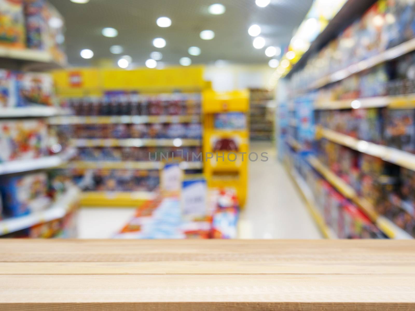 Wooden board empty table in front of blurred background. Perspective light wood over blur in kids toys store - can be used for display or montage your products. Mock up for display of product.