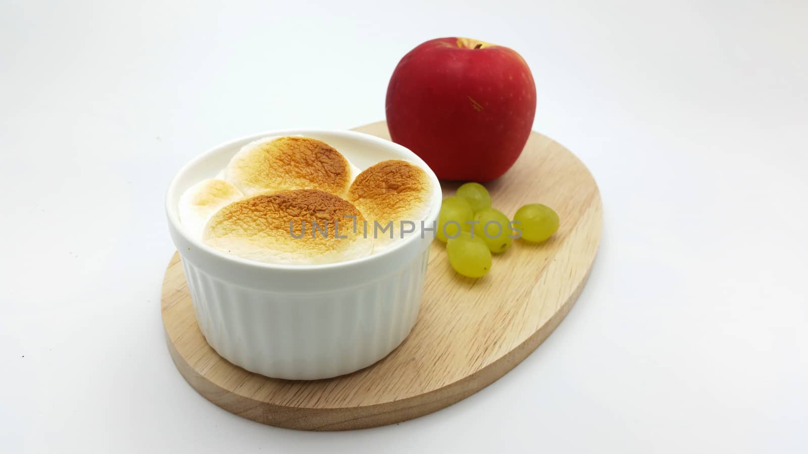 S'More dip with apple and grape on the wooden plate on the white background