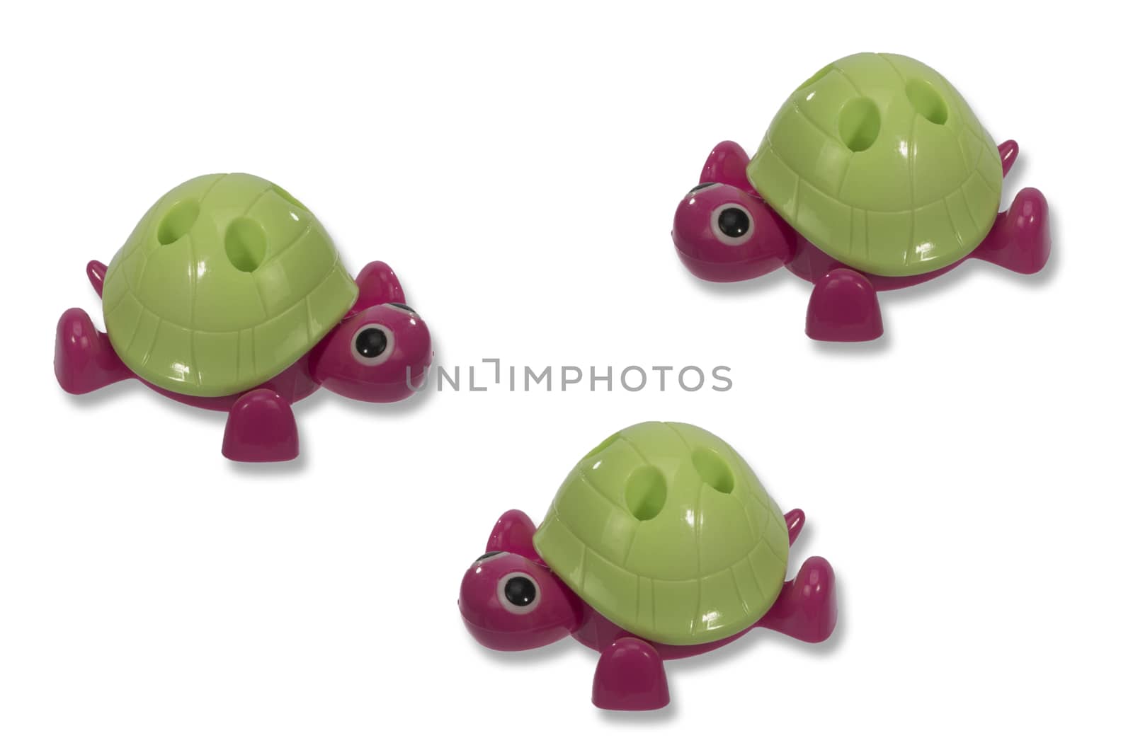 three toy turtle with a green shell creep towards each other