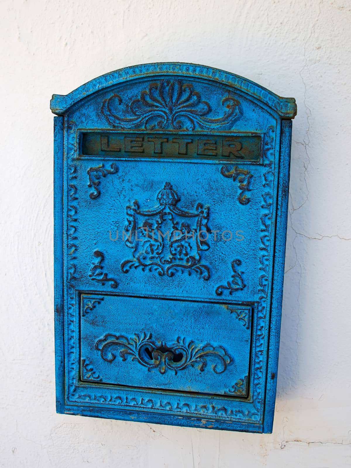 Blue mailbox on a white wall by Ronyzmbow