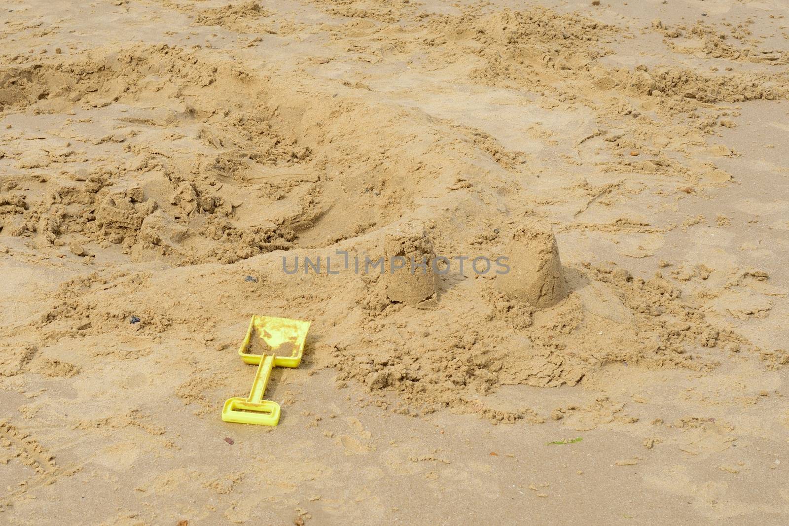 Kids spade by broken down sandcastle