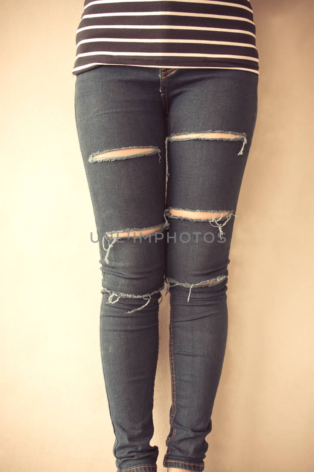 Closeup of female wearing jeans, vintage tone background by worrayuth