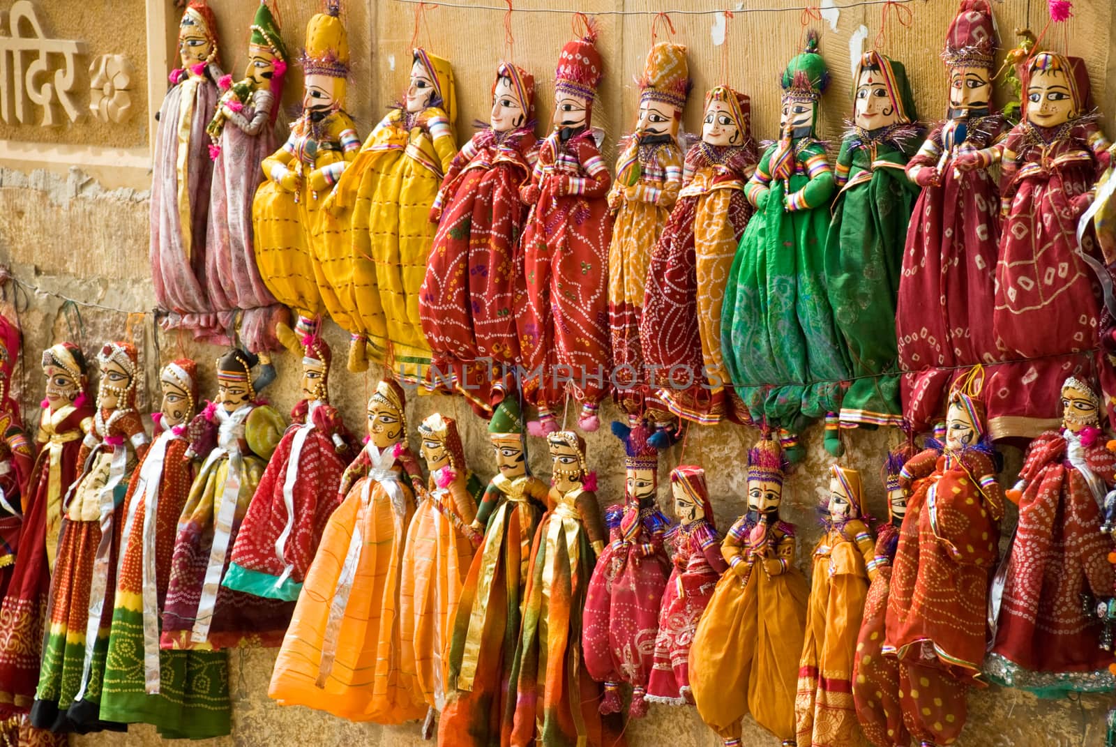 multicolored puppets hanged up to a wall in Jaisalmer, rajasthan