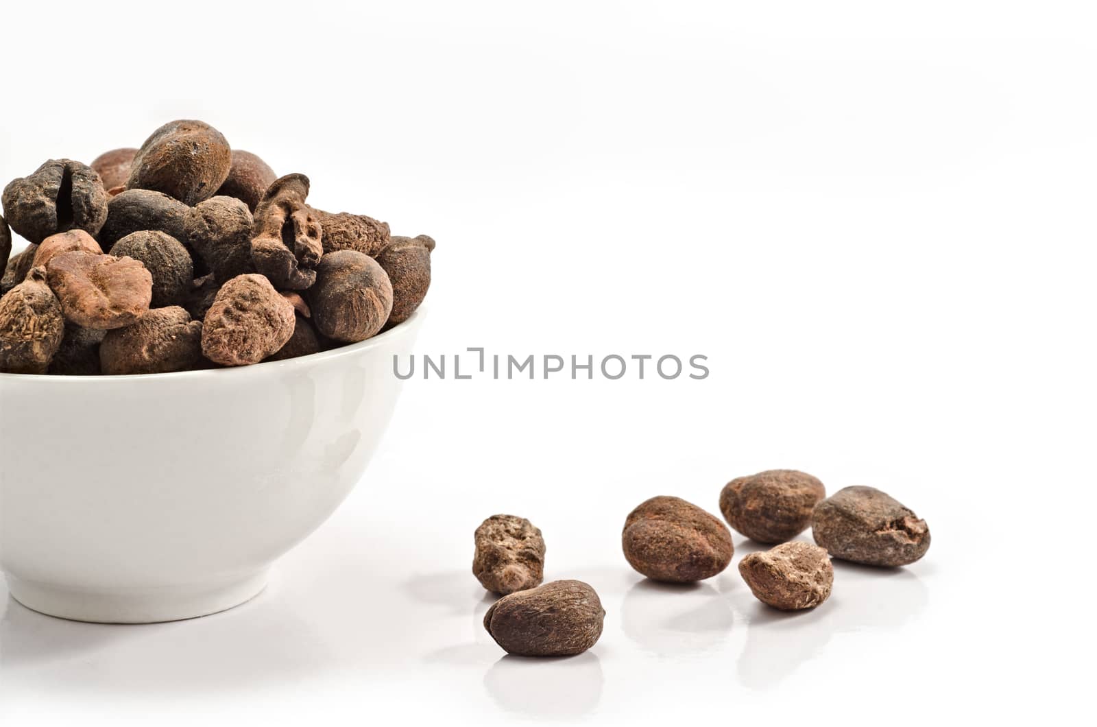 Cup full of shea nuts on white background
