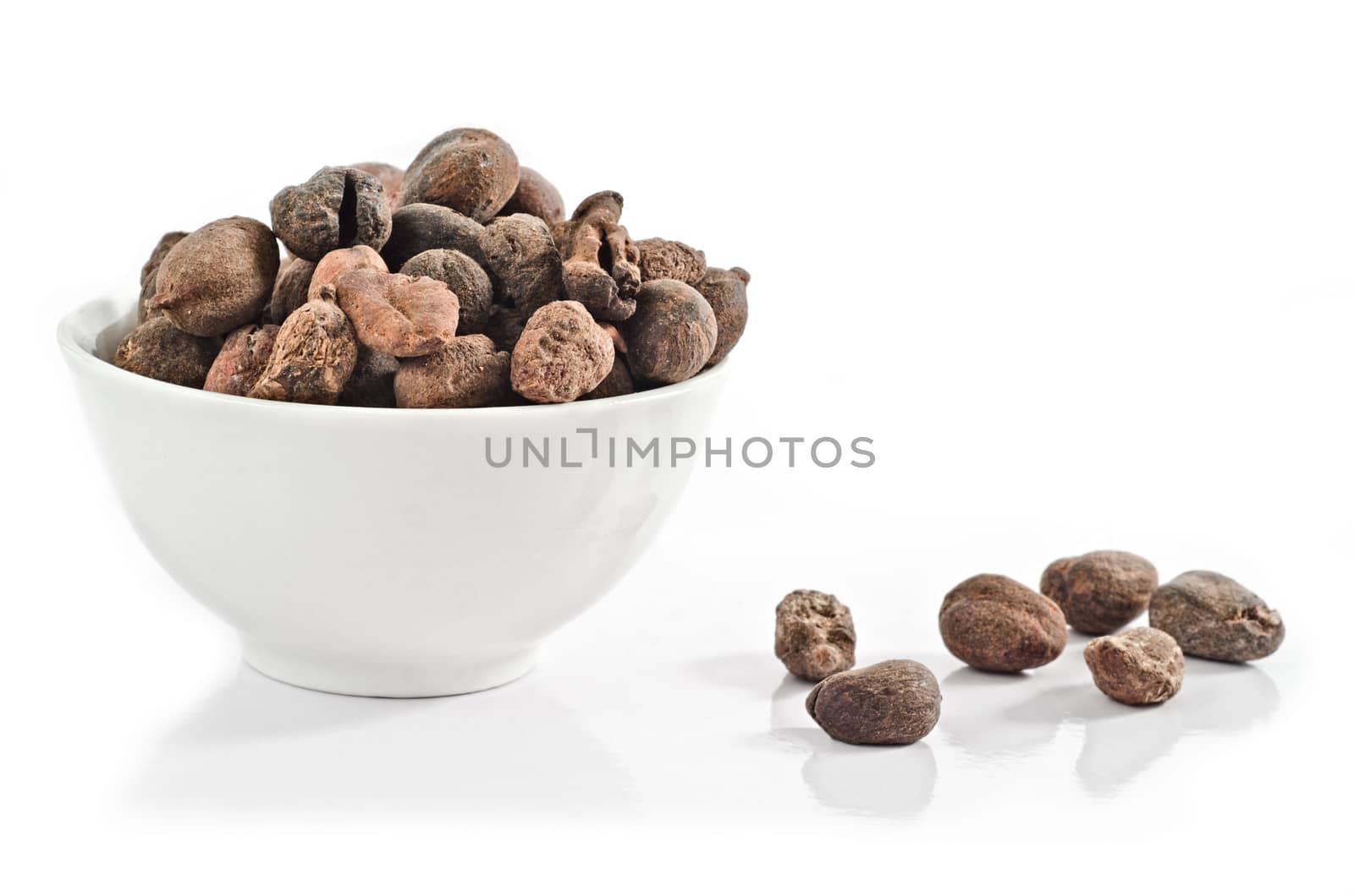 Cup full of shea nuts on white background