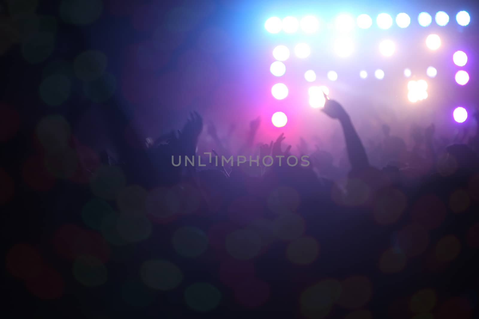 People dancing in front of a stage during a musical concert in India.