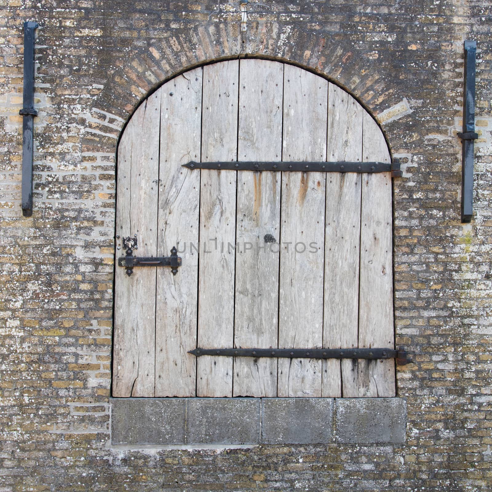 Old wooden door in a wall by michaklootwijk