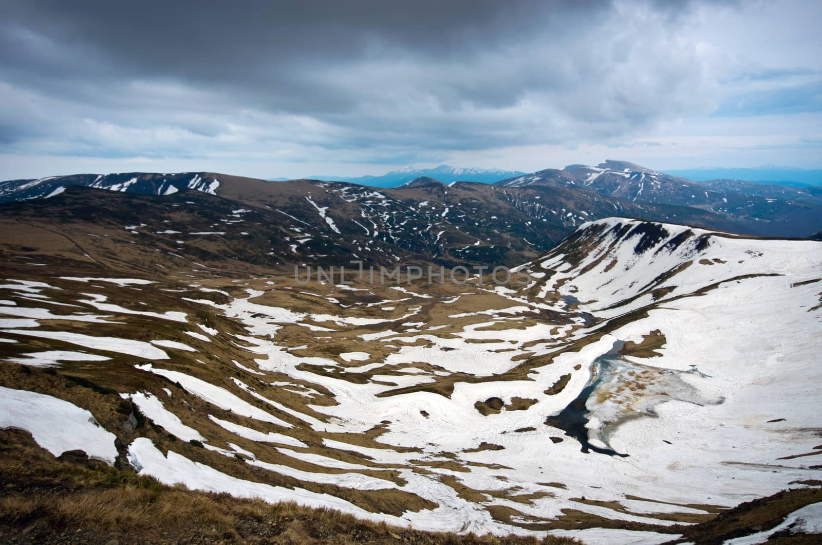 spring  calm mountain landscape with lake covered ice by dolnikow