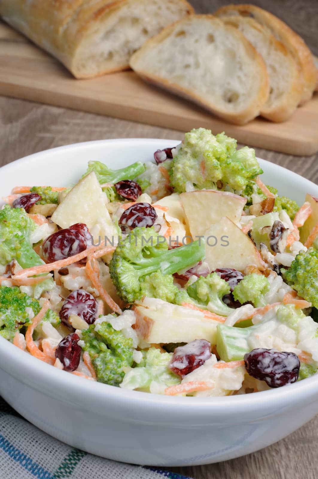 Salad of broccoli, carrots, apples, rice, cranberries and walnuts dressed with yogurt