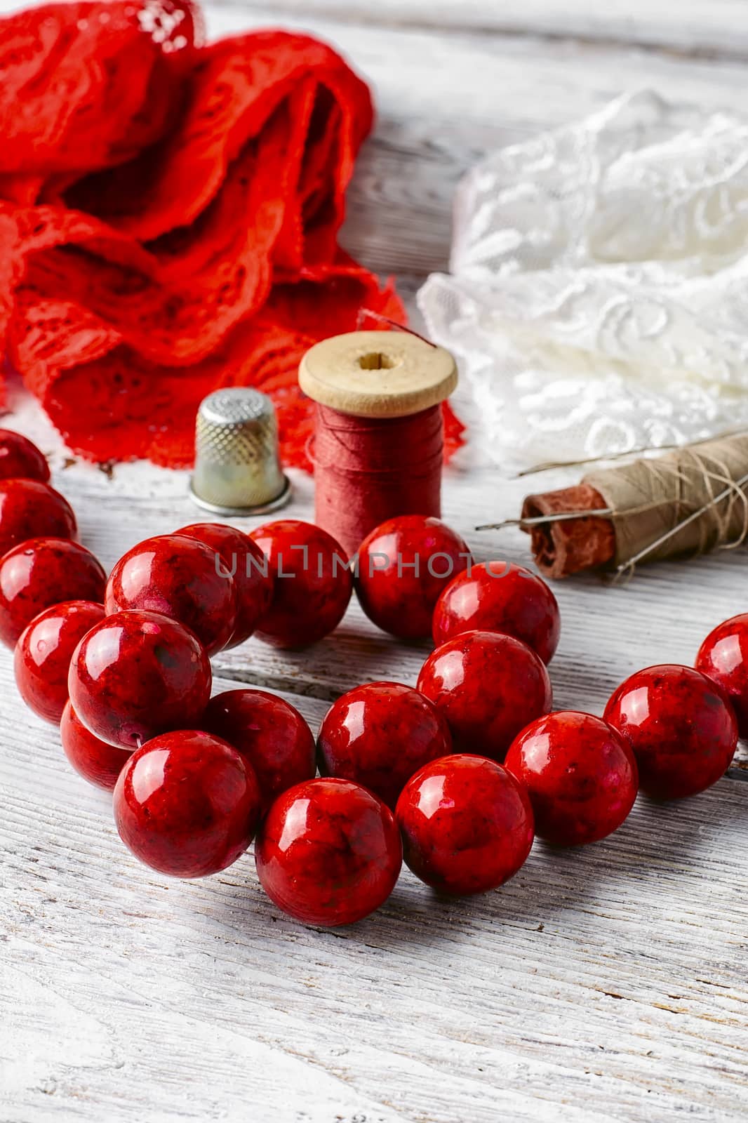Coral beads,a spool of thread and lace two colors