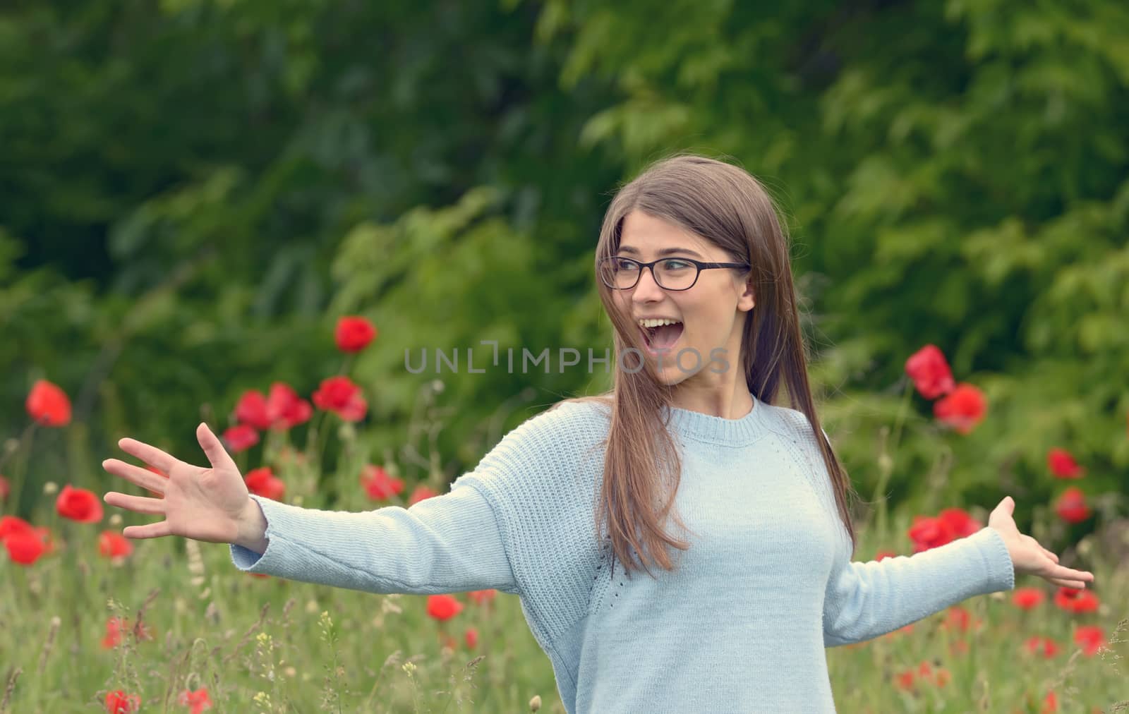 beautiful girl playing in the poppy field