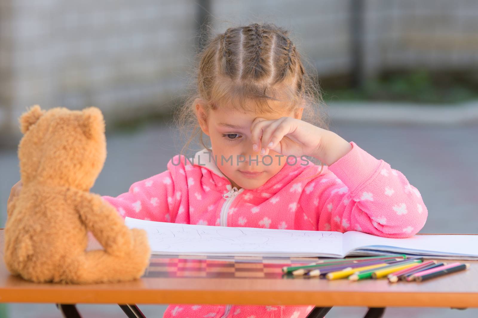 The girl does not know how to continue to draw drawing pencils
