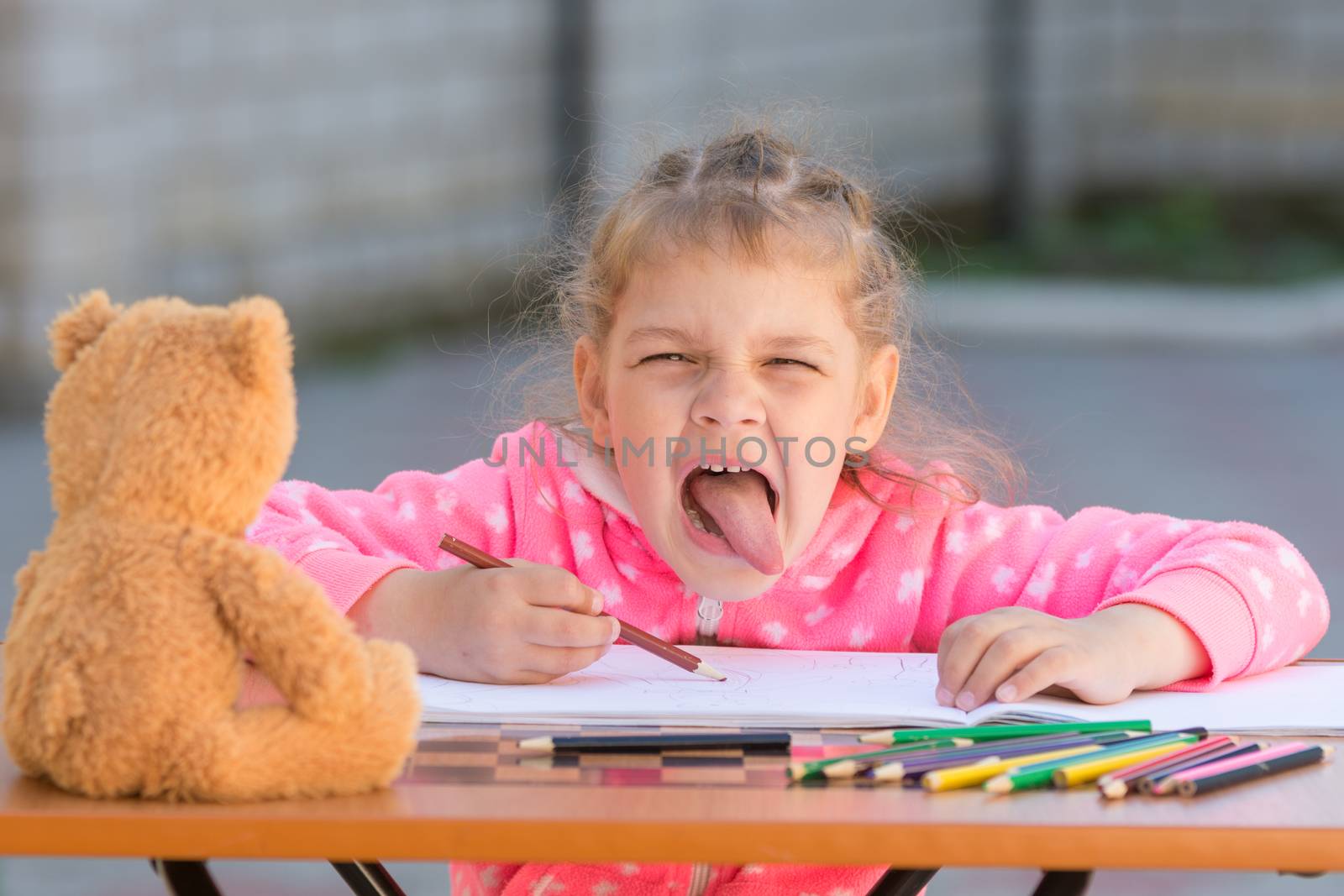 Girl shows the language in the frame drawing in the yard