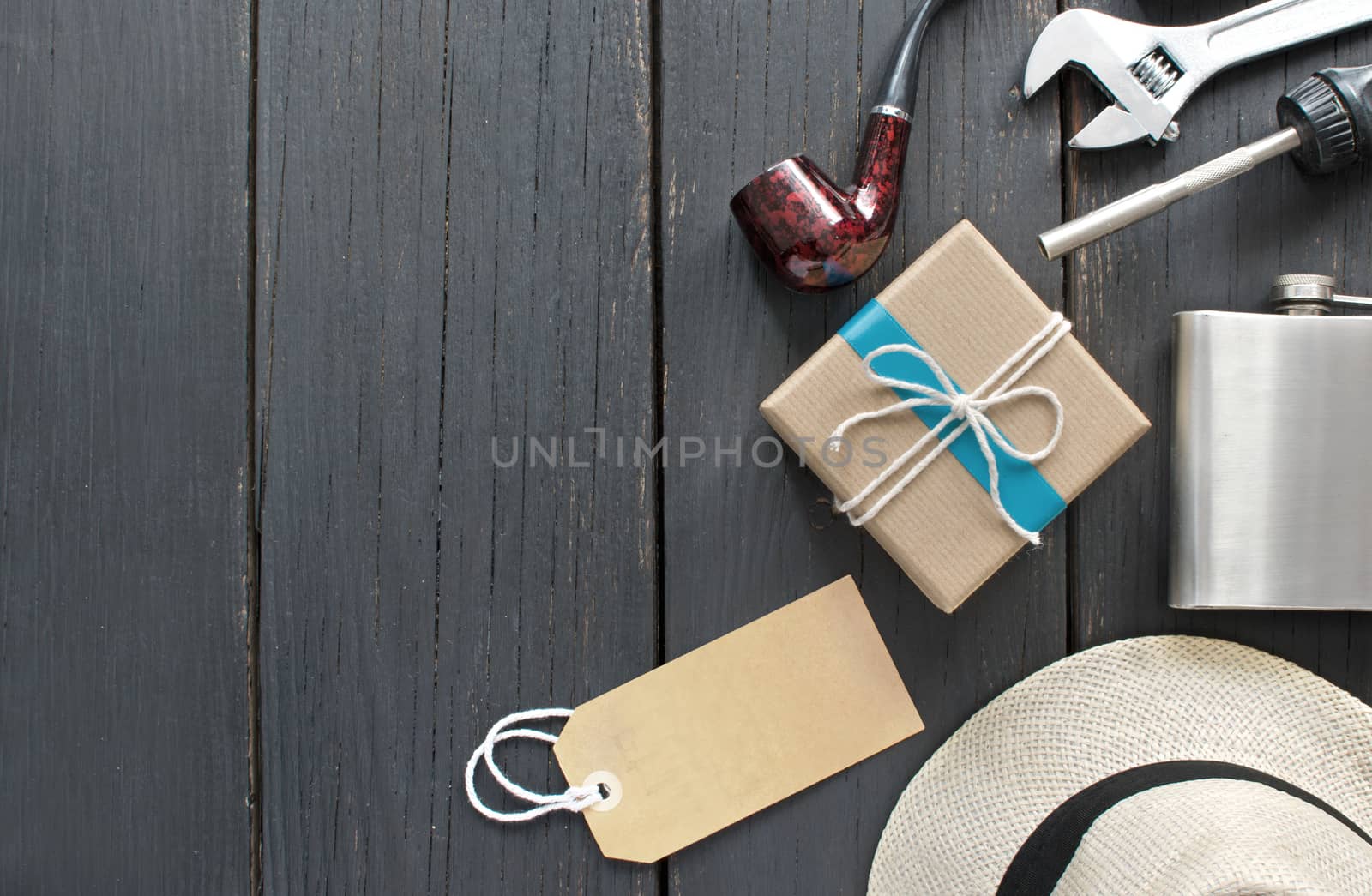 Fathers day gift box tied in blue ribbon over a wooden background with label