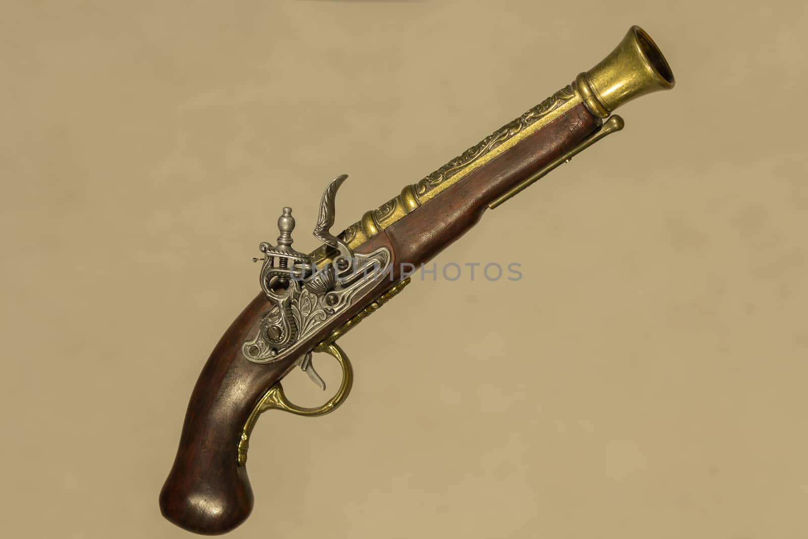 Vintage gun souvenir Brown with bronze on a beige background