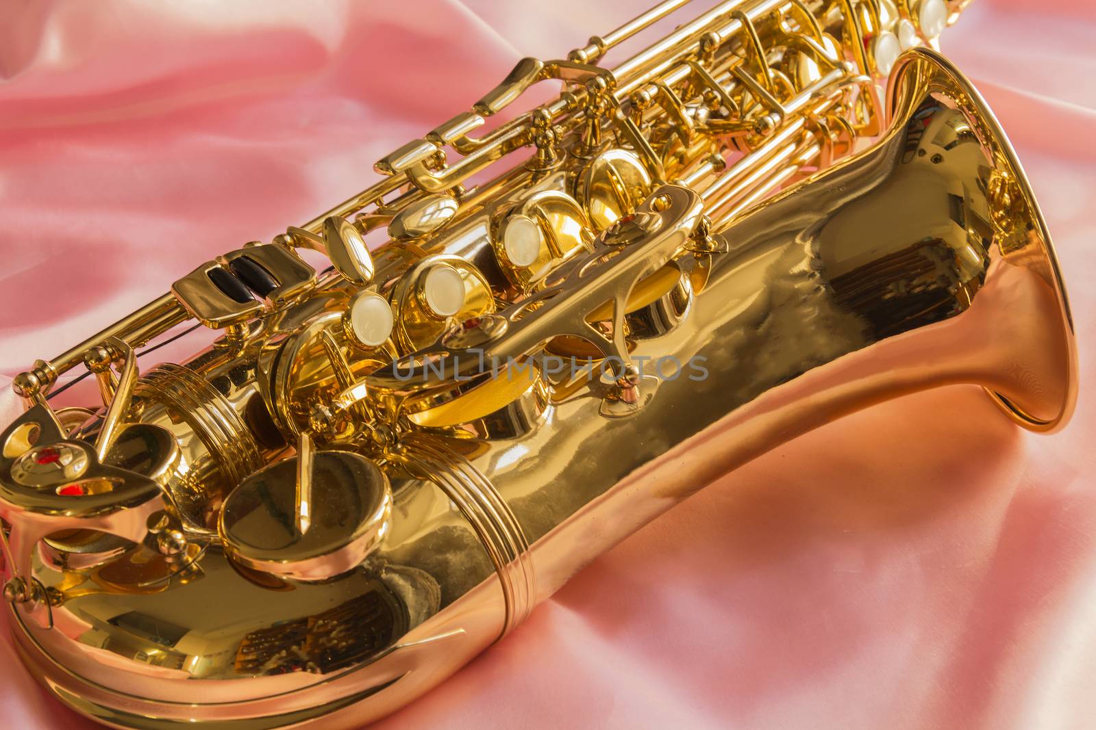 beautiful golden saxophone on delicate Pink silk background
